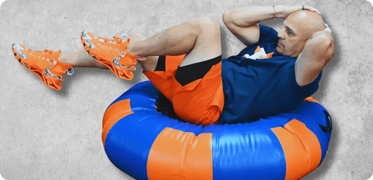Man exercising on blue and orange cushion.